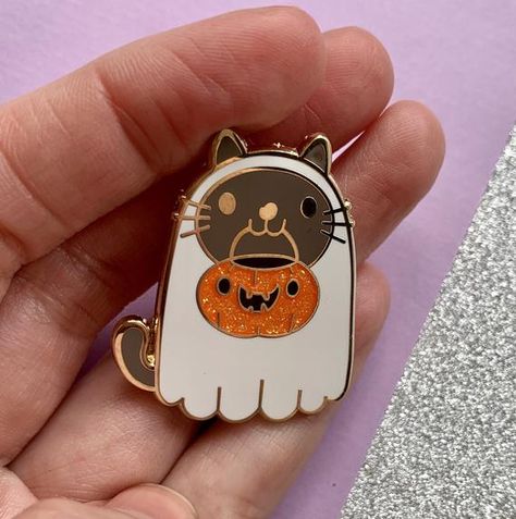 Cute and spooky enamel pin featuring a ghost cat ready to go trick or treating.Features glitter and gold plated detailing.Approx 35mm at the widest point with a rubber clutch.**This listing is for one pin only, the group photo is to show the whole range of Halloween pins**