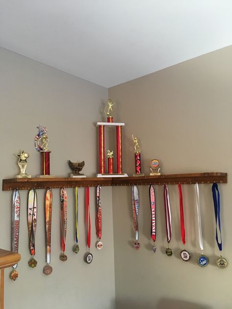 How To Display Trophies And Medals, Award Wall Display Ideas Bedroom, Ideas For Trophy Display, Award Shelf Display, Floating Shelf For Trophies, Trophy Ribbon Display Ideas, Trophy And Metal Display Ideas, Trophy And Medal Display Ideas Shelves, Sports Awards Display Ideas