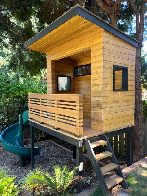 Modern cedar raised platform playhouse built for my kids in our backyard. All the landscaping and construction done by my wife and I. Playhouse On Platform, Mid Century Modern Playhouse, Kid Clubhouse, Platform Playhouse, Raised Playhouse, Modern Playhouse, Backyard Fort, Modern Playground, Modern Tree House