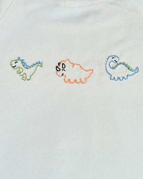 Lawson loves dinosaurs and every color is his favorite color. The trex is his favorite. This is what I designed. Aren’t the dinosaurs so cute? Order one for your little one! Every purchase of this organic top helps a child in need #handmadewithlove #organic #customhandembroidery #handembroidery #dmcembroidery #dinosaurs #dinosaurlove Embroidery Dinosaur Simple, Dinosaur Embroidery Pattern, Embroidered Dinosaur, Dinosaur Embroidery, Every Color, Children In Need, Dinosaurs, A Child, Embroidery Patterns