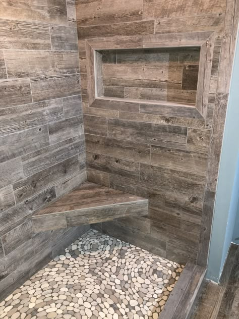 Plank tile shower walls. River rock pebble shower pan. W.R. Jones Tile & Stone West Bend WI. #westbendtile #wrjonestilestone #wisconsintile Rock Shower Floor, تصميم دورة مياه, Rustic Bathroom Shower, Rock Shower, Makeover Kamar Mandi, Cabin Bathrooms, Rustic Bathroom Designs, Master Shower, Shower Walls