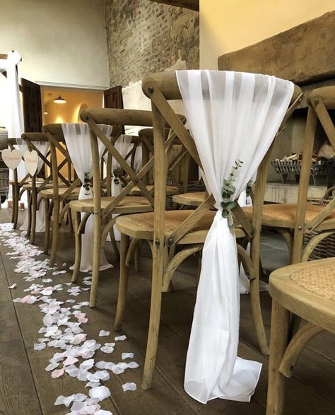 Beautiful white chiffon drapes with sprig of eucalyptus on a cross back chair. Created by Ambience Teesside at Middleton Lodge. Chair Decor | Wedding Chairs | Wedding Chair Decor | White Wedding Colour Palette | Rustic Wedding | Foliage Wedding | Wedding Decor | Wedding Decorations | Wedding Chair Decorations | Wedding Decor Ideas | Wedding Decor Inspiration | Wedding Theme Chair Decorations Wedding, Chair Decor Wedding, Chair Drapes, Wedding Foliage, Diy Chair Covers, Spring Wedding Color Palette, Wedding Chair Sashes, Rustic Style Wedding, Wedding Chair Decorations