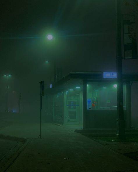 This shows a bus stop that’s lit in an eerie green foggy way. Dark Foggy Aesthetic City, Green Foggy Aesthetic, Foggy Green Aesthetic, Dark City Photography, Foggy City Night, Foggy Liminal Space, Fog Aesthetic City, Foggy Aesthetic City, Foggy City Aesthetic