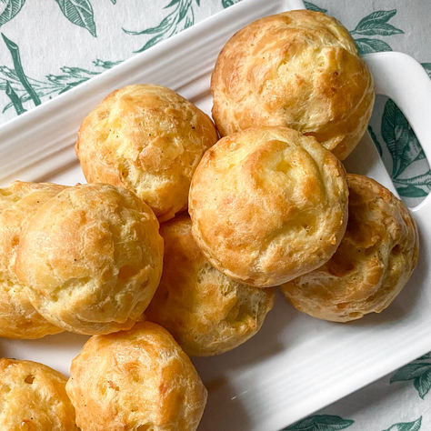 Light and airy on the inside and slightly crisp on the outside, gougères (cheese puffs) make crowd-pleasing appetizers, snacks, or accompaniments to your favorite mocktail or glass of wine. #appetizers #cheesepuffs #cheddar #parmesan #gougeres #frenchrecipes #apero #horsdoeuvres #snacks #partyfood #entertaining #holiday #baking #savorybaking #pateachoux #pastry How To Make Pate, Gougeres Recipe, Wine Appetizers, Cheese Puff, Cream Puff Recipe, Swirl Brownies, Lemon Curd Filling, Crowd Pleasing Appetizers, Puff Recipe