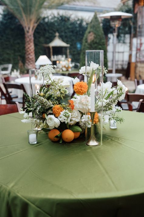 The color scheme of this wedding took center stage at Race and Religious. Pops of orange throughout the centerpieces atop linens in shades of green and white. We also loved using lamps on some tables for a warm and comforting feeling. The courtyard here dazzles, and these natural green and orange hues gave so much sophistication and charm. Green And Orange Wedding Table Decor, Green White And Orange Wedding, Green And Orange Wedding Theme, Orange Centerpieces, Orange Wedding Themes, Wedding Ambiance, Orange Hues, Green Table, June Wedding