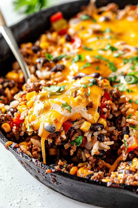 This one-pan taco skillet is a tasty meal no one can resist! It's loaded with ground beef, veggies, rice, black beans, corn, and plenty of cheese for a true fiesta. Healthy Ground Beef Skillet, Taco Casserole Bake With Rice, One Pan Taco Skillet, Skillet Taco Rice, Taco Pan, Black Bean Skillet Dinner, One Pan Mexican Beef And Rice, Beef Skillet Fiesta, Black Bean Rice Casserole