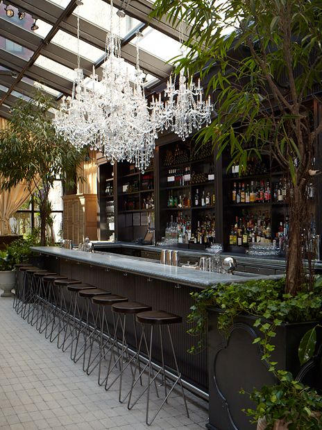 White tile floor, white bar top, dark glass door cabinets dark wood bar stools, chandeliers (Isola Trattoria & Crudo Bar) Dark Wood Bar, Wood Bar Cabinet, Bar Interior Design, White Bar, Bar Interior, Bar Design Restaurant, Dark Interiors, Wood Bar, Restaurant Interior Design