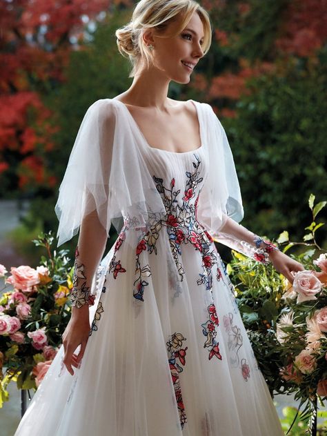 Regal tulle wedding dress with voile sleeves and coloured embroidery | Nicole Milano Flowy Floral Wedding Dress, Boho Embroidered Wedding Dress, Colourful Floral Wedding Dress, Regal Dress, Celtic Bride, Embroidery On Tulle, Spring Wedding Dress With Multicolor Embroidery, Multicolor Embroidered Semi-stitched Wedding Gown, Wedding Dress With Multicolor Floral Embroidery