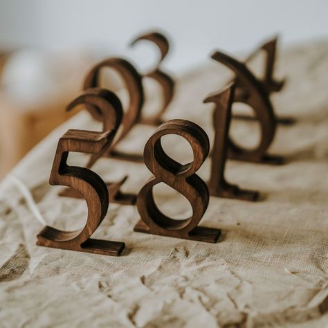 Rustic Wooden Wedding Table Numbers Add elegance and rustic charm to your wedding with our Wooden Wedding Table Numbers. Perfect for rustic-themed weddings, these custom wooden signs are not just functional but also beautifully designed to complement your table decor. They leave a memorable impression on your guests with their high-quality craftsmanship. Materials: Crafted from durable plywood in rustic brown and black, and sleek ashwood in white, our table numbers are built to last and look gre Mountain Wedding Table Settings, Wedding Table Number Ideas Rustic, Wedding Table Numbers Elegant, Fall Table Numbers Wedding, Farmhouse Table Wedding Decor, Farmhouse Table Wedding, Rustic Table Numbers Wedding, Restaurant Table Numbers, Unique Table Numbers Wedding