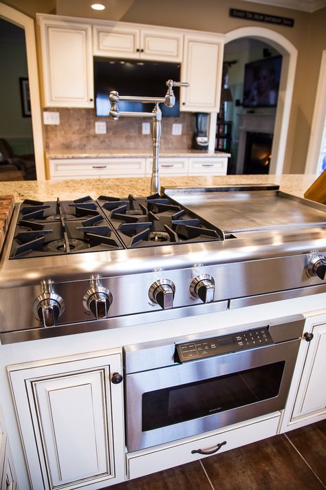 This remarkable kitchen has maple cabinets with presidential doors. A wall was removed to make way for the large island. The island seats 12 or more and features a hibachi cooktop and range hood. See more at: http://www.kitchensaver.com/kitchen/timonium-md/ Kitchen Island With Cooktop, Island With Stove, Kitchen Island With Stove, Contemporary Kitchen Island Lighting, Unique Kitchen Design, Kitchen Stove, Kitchen Island Design, Kitchen Island Lighting, Unique Kitchen