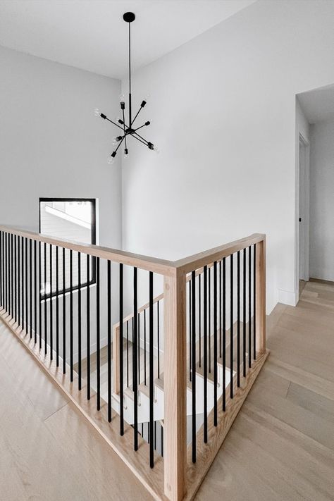 Captivating stair railing with a combination of natural wood and black metal spindles. Black Metal Spindles, Natural Wood And Black, Black Stair Railing, Wood Railings For Stairs, Diy Stair Railing, Metal Stair Railing, Interior Stair Railing, Metal Spindles, Wood And Black Metal