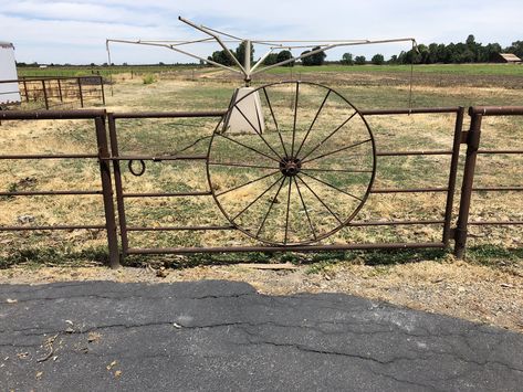 Really nice sturdy gate using metal wagon wheel. Has a great latch and very heavy duty hinge. Wagon Wheel Gate, Wagon Wheel Driveway Entrance, Metal Wagon Wheel Ideas, Sliding Gate Ideas, Entrance Decoration Ideas, Farm Fence Gate, Entrance Walls, Ranch Entrance, Property Gates