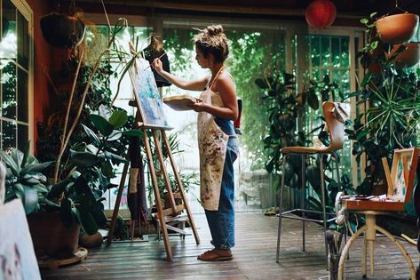 Indoor shot of professional female artist painting on canvas in studio with plants. Studio With Plants, Artist Painting On Canvas, Female Artists Painting, Art Studio Space, Art Studio Room, Art Studio Design, Painter Painting, Art Studio At Home, Female Artist