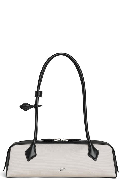 This covetable shoulder bag from Alaïa features an elongated East/West silhouette and gets its fitting name from the French word for the Dachshund dog breed. The colorblocked design offers the perfect pop of contrast to your looks, and the rolled straps are the perfect length for slinging over your shoulder. Two-way top-zip closure Shoulder straps Interior wall pocket with pull-out mirror Leather lining Textile with leather trim Made in Italy Designer Handbags Designer Staud Rectangular Shoulder Bag, Modern Rectangular Staud Bag, Modern Staud Shoulder Bag, Chic Staud Shoulder Bag With Handles, Modern Staud Shoulder Bag With Detachable Handle, Sequins Top Outfit, Alaia Bag, Designer Things, Carrie Bradshaw Outfits