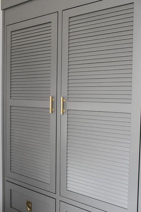 Charcoal gray laundry room features charcoal gray louvered cabinets adorned with brass handles built above stacked gray drawers adorned with vintage brass ring hardware. Mediterranean Laundry, Louvered Door Ideas, Gray Beadboard, Gray Laundry Room, Beadboard Cabinets, Contemporary Laundry, Cottage Laundry, Contemporary Laundry Room, Landry Room