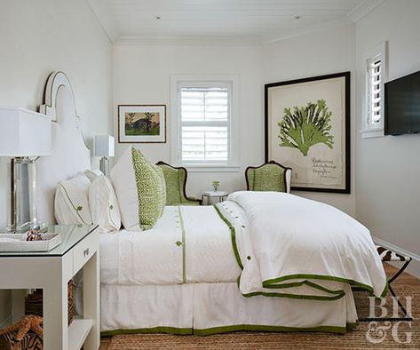 Give an all-white bedroom a luxury hotel vibe with a single accent color that carries throughout the bedding, furniture, and wall art. Grass green is featured on the trim of the duvet and the botanical print on the white bedroom walls. The same hue appears on the Euro shams on the bed and the upholstery of the wing chairs. Small White Bedrooms, Blue And Grey Bedding, White Curtains Bedroom, Green And White Bedroom, Eclectic Decor Bedroom, White Coverlet, All White Bedroom, White Wall Bedroom, Bedroom White