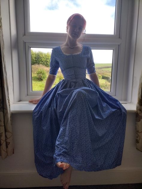 This 18th century inspired dress has a fitted bodice and half sleeve's that are trimmed with delicate white lace and fastens at the front with hook and eye closures. The full length skirt is gathered at the sides and back with pockets big enough to fit your smart phone, fastening in to place with a ties and press studs. Hand made to order out of 100% cotton with a simple white floral print. Comes in a selection of colors. Perfect for historical reenactment, LARP, special occasions or if you just 1800s Dresses Casual, Late 1800s Dresses, 1800 Dresses, Blue Dress Floral, 1800s Dresses, 19th Century Dress, Floral Dress Long, 1800's Dress, Dress Cottage