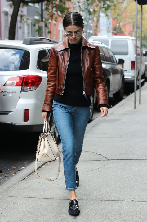 Selena Gomez wears a brown leather moto jacket, black sweater and black loafer flats. Black Loafer Outfits Women, Leather Moto Jacket Outfit, Loafer Outfits Women, Black Loafers Outfit, Brown Leather Jacket Outfit, Womens Leather Jacket Outfit, Moto Jacket Outfit, Jacket Outfit Women, Loafers Outfit