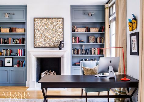 Benjamin Moore’s Templeton Gray makes the built-in bookcases stand out in the library. “It actually takes on a more blue cast with the light in this room,” says McFadden. A contemporary painting and a bronze sculpture bring liveliness to the limestone fireplace. Home Library Bookshelves, Airy Office, Bookshelves Around Fireplace, Blue Bookshelves, Painted Built Ins, Office With Fireplace, Fireplace Bookshelves, Bookshelf Plans, Library Bookshelves