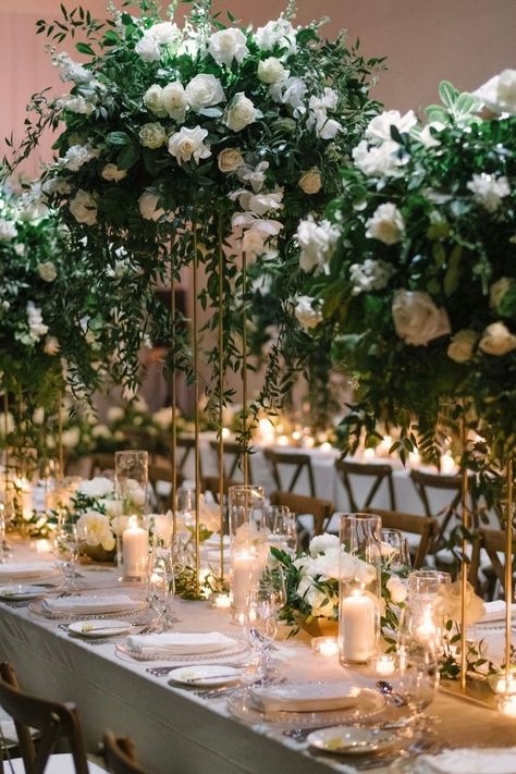 Stunning tablescape with tall green floral arrangements and glowing candlelight for a luxurious touch. Greenery Tablescape, Green Floral Arrangements, Green Wedding Florals, Green Wedding Centerpieces, Head Table Wedding, Head Tables, Reception Inspiration, Tall Centerpieces, Wedding Reception Inspiration