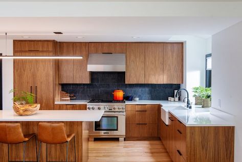 The kitchen in this whole home remodel project was gutted and received all new appliances and finishes – including walnut cabinetry, white quartz countertops, and porcelain backsplash tile. See more of this project and others on our website! Mid Mod Kitchen, Warm Kitchen, Mid Century Modern Kitchen, Black Walnut Wood, Remodel Kitchen, Kitchen Inspiration Design, Updated Kitchen, Black Walnut, Interior Design Studio