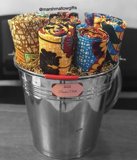 Bride’s cloths wrapped in a mettalic bucket for engagement wrapping. Traditional African Wedding, Wrap Clothes, Engagement Gift Baskets, Traditional Engagement, Bridal Boxes, Bridal Gift Wrapping Ideas, Wedding Gift Wrapping, Gift Wrapping Ideas, How To Wrap