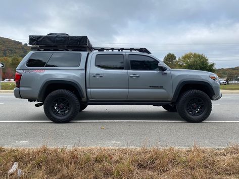 3rd gen toyota Tacoma cement grey 2018 overland lifted 33” falken wildpeak tires trd off road package 4x4 4wd Ranch fiberglass camper shell topper prinsu rack decked bed system yakima roof top tent Overland Toyota Tacoma, Tacoma With Camper Shell, Toyota Tacoma With Camper Shell, Toyota Tacoma Camper Shell, Tactical Truck Ideas, Tacoma Roof Rack, Custom Toyota Tacoma, Toyota Tacoma Overland, Tacoma Camper Shell