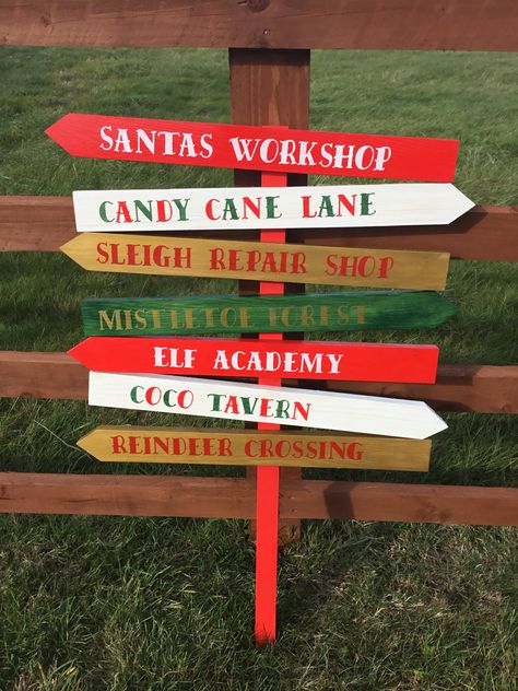 Directional Christmas sign post. The set comes with 7 directional signs, Santa’s workshop, candy cane lane, sleigh repair shop, mistletoe forest, elf academy, coco tavern & reindeer crossing. We hand make the signs from solid wood and hand paint them in festive colours giving them a real rustic traditional look. each arrow measures 60cm x 6cm and stand 1m tall. £40 Available from www.dreamyhomes.co.uk Holiday Woodworking Projects, Christmas Booth, Elf Christmas Decorations, Candy Cane Lane, Outside Christmas Decorations, Christmas Decorations Diy Outdoor, Christmas Signs Wood, Christmas Projects Diy, Christmas Garden