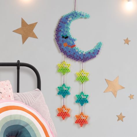 Add this whimsical wall hanging to a child’s room for a fresh pop of color. It’s easy to connect the fuse bead components using embroidery thread. Perler Bead Garland, Turkey Place Cards, Whimsical Moon, Star Wall Hanging, Hamma Beads, Beads Ideas, Bead Frame, Butterfly House, Easter Greeting Cards