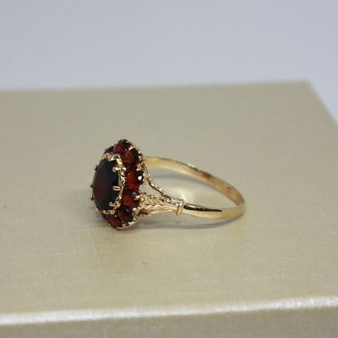 Vintage, Beautiful estate, handcrafted Brown Garnet ring for women, made from 18k solid Yellow gold, Oval shaped natural Garnet in a center surrounded by 10 round smaller stones (Garnets), set on prongs. Total weight of the item is 4g. Polished finish. Excellent condition. Please look at all pictures and If you have any questions, ask, we will be happy to assist you. Note: Store certificate is available, please ask. Item will come in a nice gift box, that will make it look even more special for a someone you love. Item priced for sale. Thank you for shopping with us. Georgian Era Engagement Ring, Red Engagement Ring Unique, Vintage Oval Ring, Vintage Ruby Ring, Vintage Gold Ring, Garnet Wedding Rings, Jewels Rings, Garnet Jewelry, Dream Engagement Rings