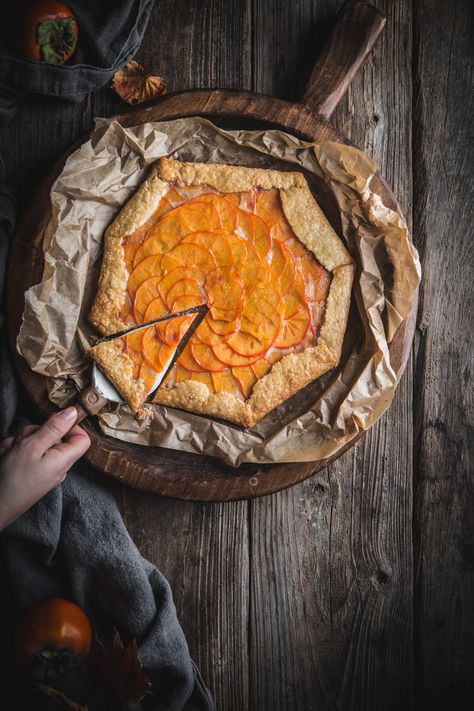 Persimmon Galette with Mascarpone Filling by Eva Kosmas Flores   This persimmon galette contains layers of persimmons soaked in a cinnamon syrup, with a vanilla mascarpone filling underneath, wrapped in a flakey crust. #persimmon #galette #mascarpone #cinnamon #vanilla #adventuresincooking #dessert Persimmon Galette, Persimmon Dessert, Enchanted Kitchen, Persimmon Bread, Family Dessert Recipes, Dessert Fall, Mascarpone Filling, Rustic Food Photography, Persimmon Recipes