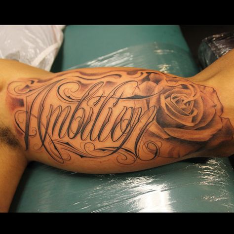 Script Rose By Jeffry Mendoza Email Tattoo@jeffrymendoza.com Wife Name Tattoos For Men, Bicep Name Tattoo, Bicep Name Tattoo Men, Wife Name Tattoo For Men On Arm, Name Tattoo With Roses Forearm, Inner Bicep Script Tattoo, Tattoo Men Bicep, Wifes Name Tattoo Ideas For Men, Wife Name Tattoo For Men