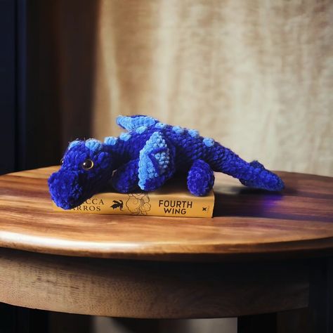 Sgaeyl! 🐉 💙 Crocheted another dragon because, let's face it, I can't get enough! Meet Sgaeyl from Fourth Wing, joining Tairn and Andarna. Took a stab at making her daggertail, too, of course. 🗡️ Now, onto the next dragon..... Feirge, Deigh, Aotrom, or Sliseag? 🤔 Decisions, decisions! Amazing no-sew dragon pattern by @crochetbygenna #dragon #fourthwing #ironflame #onyxstorm #rebeccayarros #obessed Fourth Wing Crochet Patterns, Fourth Wing Crochet, Wing Crochet, Decisions Decisions, Fourth Wing, Dragon Pattern, Crochet Stuff, Fiber Art, Crochet Projects