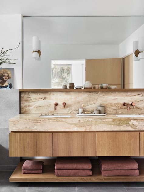 Organic themes appear throughout the house, including in this downstairs bathroom. Brass faucets by Graff complement tan marble, while opal Edie sconces by Lightmaker Studio, artwork by Joshua Dai and an assortment of ceramics by Linette Dai lend artisanal touches. Pink Sink, Earthy Modern, The Shade Store, White Faucet, Upholstery Bed, Luxe Interiors, Kitchen Cabinetry, Kitchen Fixtures, Interior Design Firms