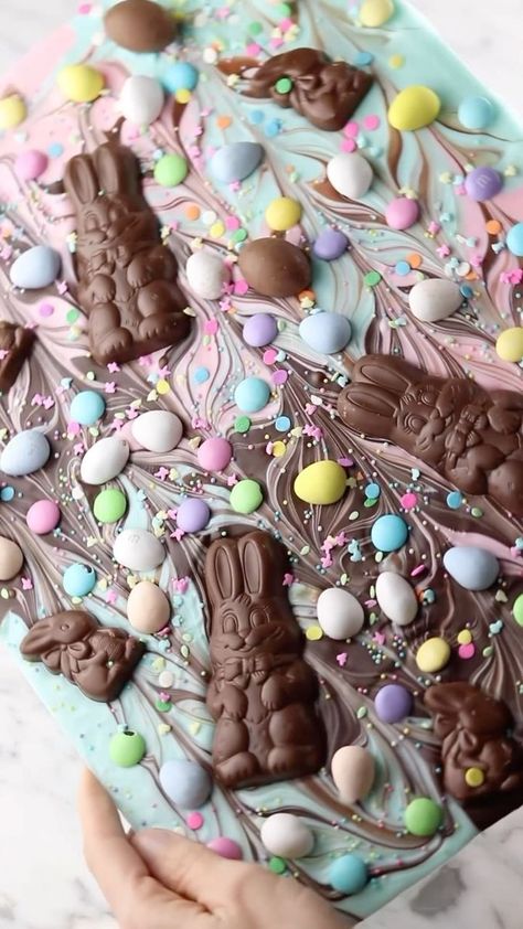 Easter Chocolate Bark 🐣🍫 What’s your Easter candy of choice? I have a weakness for Cadbury mini eggs! You’ll need- -milk chocolate bars -pink and blue colored chocolate bars (OR melting wafers) -mini Easter eggs -chocolate Easter bunnies -sprinkles Melt chocolate bars on a baking tray for 10 minutes at 100F in the oven. If using wafers, heat in the microwave for 30 second bursts until completely melted- stirring in between intervals. Swirl the colors together with a knife and add all the Easter Bark Candy, Easter Chocolate Bark, Easter Bark, Colored Chocolate, Easter Deserts, Cadbury Mini Eggs, Chocolate Melting Wafers, Easter Snacks, Fluff Desserts