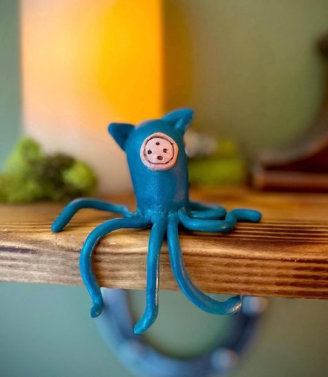 Add a touch of unique charm and a dash of eerie appeal to your space with this handmade clay squid inspired by the enchanting world of Coraline. Crafted with meticulous detail, this one-of-a-kind creation captures the quirky and slightly mysterious vibe of the beloved film. Perfect for sitting on your desk, bookshelf, or table, this squid figurine is designed to be a conversation starter and a unique addition to your decor. Whether you're a fan of Coraline or simply appreciate unique handmade art, this little squid will bring a bit of that otherworldly magic into your life. Each squid is carefully sculpted and painted by hand, ensuring that no two are exactly alike. The detailed textures and subtle color variations make each piece a true work of art. Details: -Hand-sculpted from high-quali