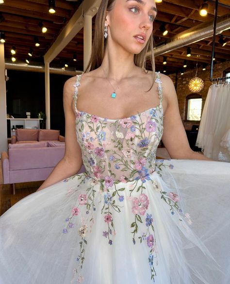 Who says wedding gowns have to be all white? 🌸⁠ ⁠ This National Color Day, we’re showcasing gowns with a pop of color - like this beauty by Stella York! Style 8063 features whimsical florals in addition to a soft tulle skirt and scoop neckline. We're in love!⁠ ⁠ Ready to find your colorful gown? Check out the link in our bio to book your appointment today! ♥ Pastel Floral Wedding Dress, Floral Wedding Dress Colored, Pastel Wedding Dress, Pastel Wedding Dresses, Stella York Style, Whimsical Florals, Polka Dot Wedding Dress, Embroidered Wedding Dresses, Colorful Gown