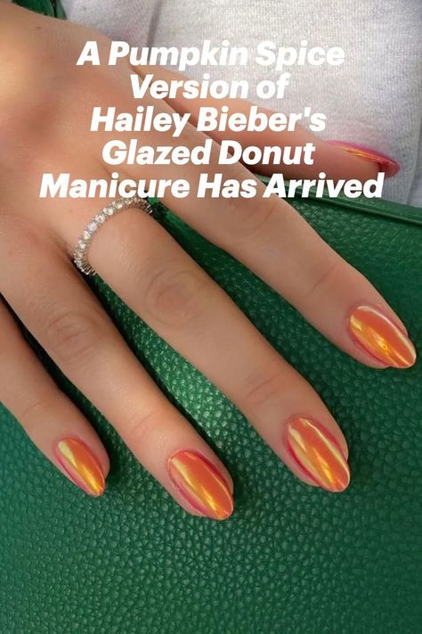 Orange almond-shaped nails holding a green purse Orange Glazed Donut Nails, Glazed Pumpkin Nails, Hailey Bieber Orange Nails, Orange Hailey Bieber Nails, Burnt Orange Glazed Nails, Glazed Donut Nails Orange, Glazed Orange Nails, Iridescent Orange Nails, Fall Iridescent Nails