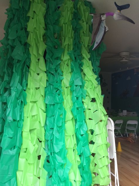 I used plastic table cloths for these vines. I fastened them up to the wall with 3M hooks, and hung the vines over a a clear Stretch Magic jewelry cord. Makes hanging a lot of these simple to put up and take down. Dinosaur Vbs, Plastic Tablecloth Backdrop, Diy Jellyfish Decoration, Display Backdrop, Tablecloth Backdrop, Jungle Vines, Jungle Theme Decorations, Jungle Crafts, Mystery Island