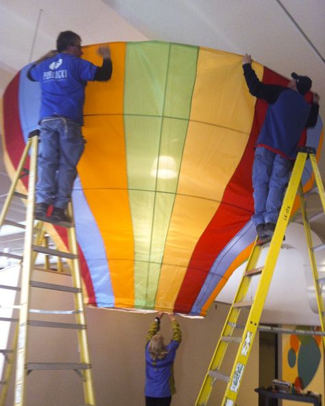 Installation of a hot air balloon display we produced for the Children's Museum of Green Bay. Hot Air Balloon Ceiling Decor, Giant Hot Air Balloon Diy, Hot Air Balloon Display, How To Create A Hot Air Balloon With Balloons, Hot Air Baloon Decoration Idea, Hot Air Balloon Photo Booth, Diy Large Hot Air Balloon, Hot Air Balloon Prop, Hot Air Balloon Installation