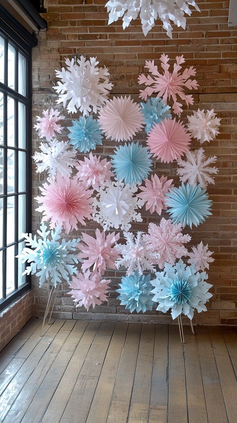 Wall adorned with pink, blue, and white paper snowflakes for an ice princess party, with origami flowers in front. Snowflake Backdrop, Ice Princess Party, Trendy Christmas Decor, Pastel Christmas Decor, Light Wooden Floor, Pink Snowflake, Festive Table Setting, Green Garland, Birthday Event