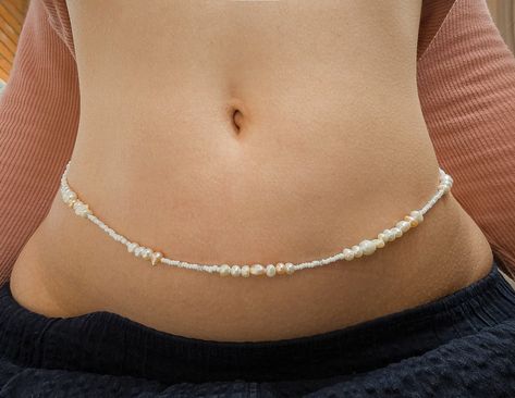 Celebrate self-love and embrace your body with these handmade waist beads, featuring a beautiful blend of beautiful high quality freshwater pearls and white seed beads. Each strand is crafted with care, offering a timeless and elegant accessory that enhances your natural beauty and inspires confidence. Materials: Freshwater pearls in varying sizes and natural shades High-quality white seed beads Strong wire threading for long-lasting wear Features: Customizable to your size Lightweight and easy Body Jewelry Diy, Jeans Chain, Crochet Christmas Ornaments Free, Waist Jewelry, Crystal Bead Jewelry, Ceramic Necklace, Waist Beads, Thread Jewellery, Belly Chain