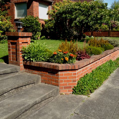 Retaining wall for a brick house Brick Wall Front Of House, Brick Retaining Wall Front Yard, Low Brick Retaining Wall, Back Yard Brick Wall, Brick Retaining Wall, Tall Brick Garden Wall, Red Brick Retaining Wall Garden, Tiered Brick Retaining Wall, Brick Wall Gardens