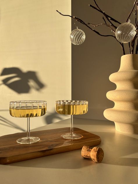 Two champagne glasses on a wooden tray Snow Day Aesthetic, Handmade Glassware, Modern Glassware, Elegant Glassware, Cocktail Tools, Unique Glassware, Festive Table Setting, Party Cocktails, Glassware Design