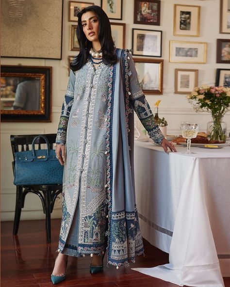 Like a secret garden, delicate flora stretch out on the mesmerising Zenith blue canvas with hints of ivory, sage and salmon peaking out in perfect harmony in ‘Larmina’. Wide borders at the hem of the shirt feature immaculate embroideries laid out in fine threads creating a breathtaking composition. #Elan #ElanUnstitched #QuintessentiallyElan #ElanWoman #WinterCollection #ElanWinter2022 #ElanWinter #élan #KhadijahShah Embroidery Designs Blue, Blue Kurti, Unstitched Dress Material, Organza Sleeves, Pakistani Designers, Suit Fabric, Stylish Dress Designs, Winter 2022, Pakistani Outfits