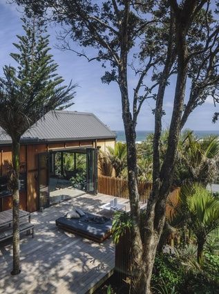 Colours, materials and composition hint at traditional South Pacific buildings. Australia Beach House, Mid Century Modern Living Room Decor, Muriwai Beach, Beach New Zealand, Ocean Forest, Houses By The Beach, Beach Architecture, New Zealand Architecture, New Zealand Beach