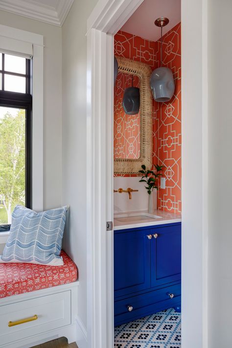 A small but bold powder room off of the living room utilizes Thibaut's Bamboo Latice wallpaper in Coral for an impactful statement, complemented by a vibrant blue vanity and woven mirror. Decorating With Orange, Bold Powder Room, Powder Room Paint Colors, Powder Room Paint, Beautiful Powder Rooms, Maine Coastline, Multi Level Deck, Boy Bath, Blue Vanity