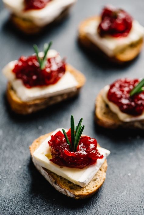 These cranberry brie bites are an easy, fun, and gorgeous cocktail party appetizer, and your guests will love them! Brie and cranberries are natural companions, and these cute little appetizer toasts are a seriously tasty combination of sweet, tart, and salty. They're vegetarian, make ahead friendly, and stress free! These cranberry brie bites are the perfect sweet and savory addition to your cocktail party menu. #appetizer #brie #christmas #vegetarian #snack Cranberry Brie Bites, Cocktail Party Appetizers, Cranberry Brie, Brie Bites, Christmas Cocktail Party, Cocktail Party Food, Cocktail Sauce, Appetizer Bites, Party Finger Foods