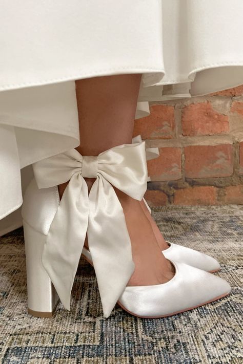 Simple, understated, stunning. The Arabella bow heel from Perfect Bridal Company is perfect for the modern bride looking for maximum impact without being over designed or fussy. Based on a stunning silhouette incorporating a high block heel and the perfect pointed toe, it is the oversized ivory satin bow which adds the perfect statement to an otherwise minimalist inspired shoe.

Available from Lily Francis Bridal. Wedding Shoes Wide Heel, Block Heels Bridal, Cute Block Heels, Bride Comfortable Shoes, Wedding Heels Bow, Chunky Wedding Shoes, Block Heel Wedding Shoes Brides, High Heels For Wedding, Wedding Heels Brides