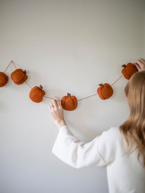 This rustic and sweet Pumpkin Garland is crafted from wool felt, adding an artisanal charm to any space during the harvest season. Perfect for creating a cozy atmosphere in your kitchen or living room. Gather your family and friends in your newly decorated home for a memorable autumnal party! Craft: These cute garlands Felt Crafts Autumn, Autumn Felt Crafts, Autumnal Party, Felt Halloween Decorations, Felt Autumn, Autumn Garland, Autumn Diy, Urban Homestead, Fashion Outfits Dresses